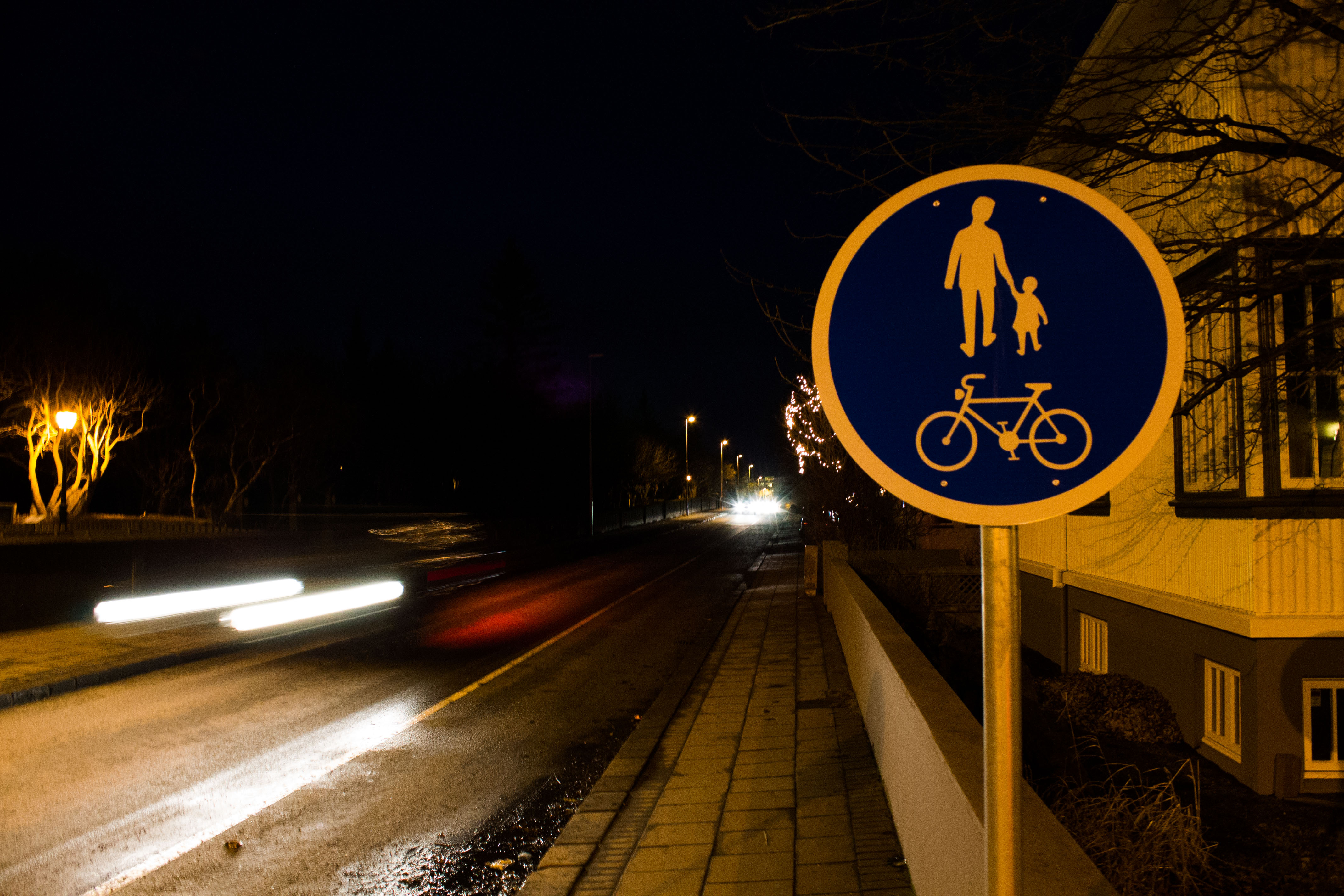 Night street with a pedestrian and cycle path sign
